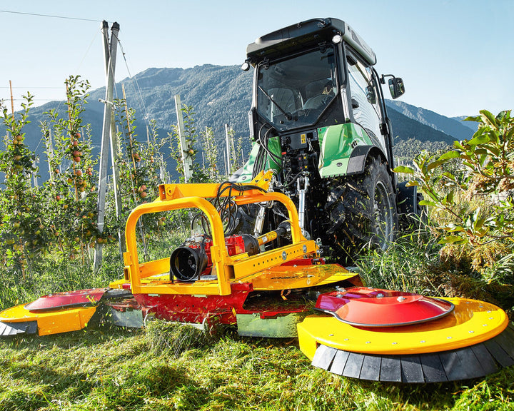 Smalspoortractor met Ilmer SMG cirkelmaaier tussen de rijen van een boomgaard