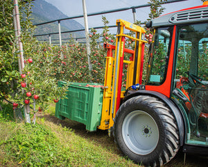 Rode smalspoortractor met Ilmer K2-D hefmast en een groene fruitkist in de appelboomgaard