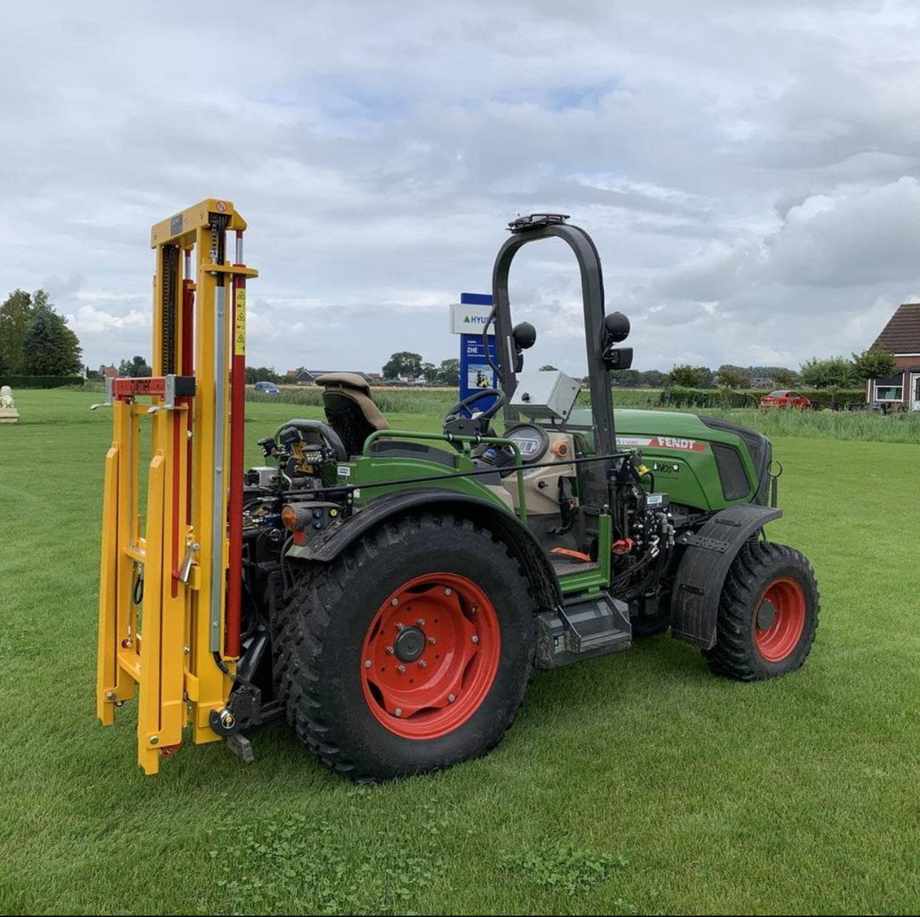 Fendt smalspoortractor met Ilmer hefmast tussen de fruitrijen